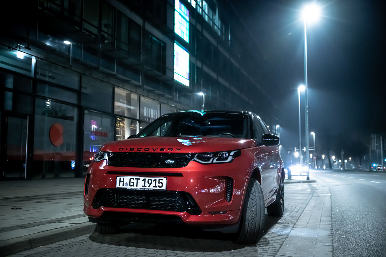 Red SUV standing in a urban sorrounding at night